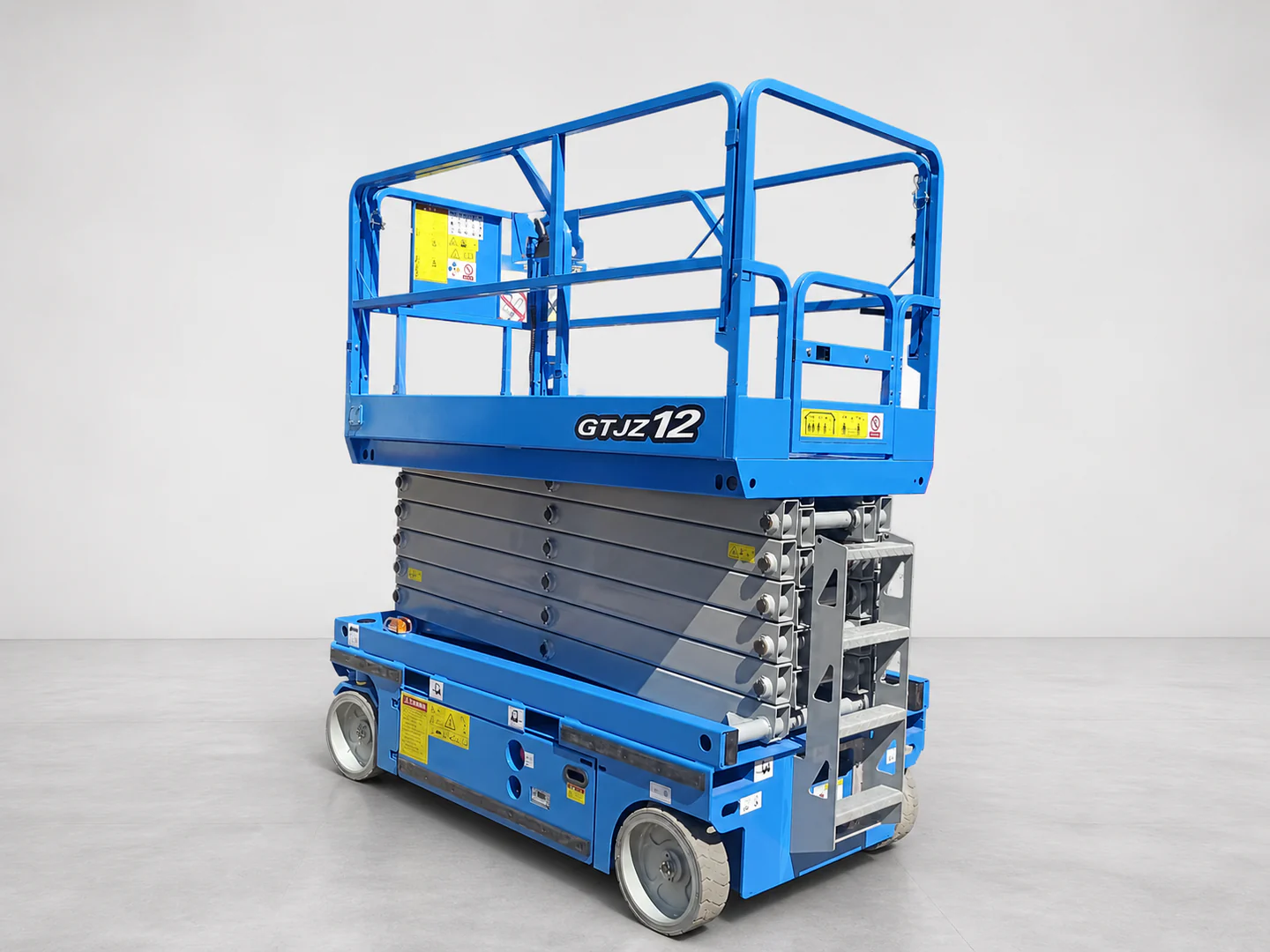 Blue scissor lift in a lowered side three-quarter view