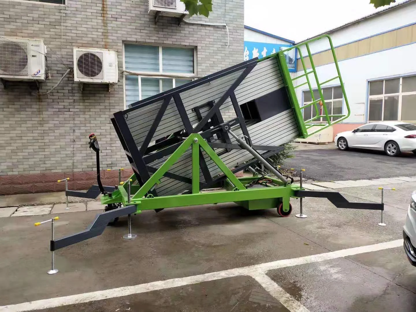 Complete multi-mast lift tilted into its transport position, with stabilizers visible outside a building