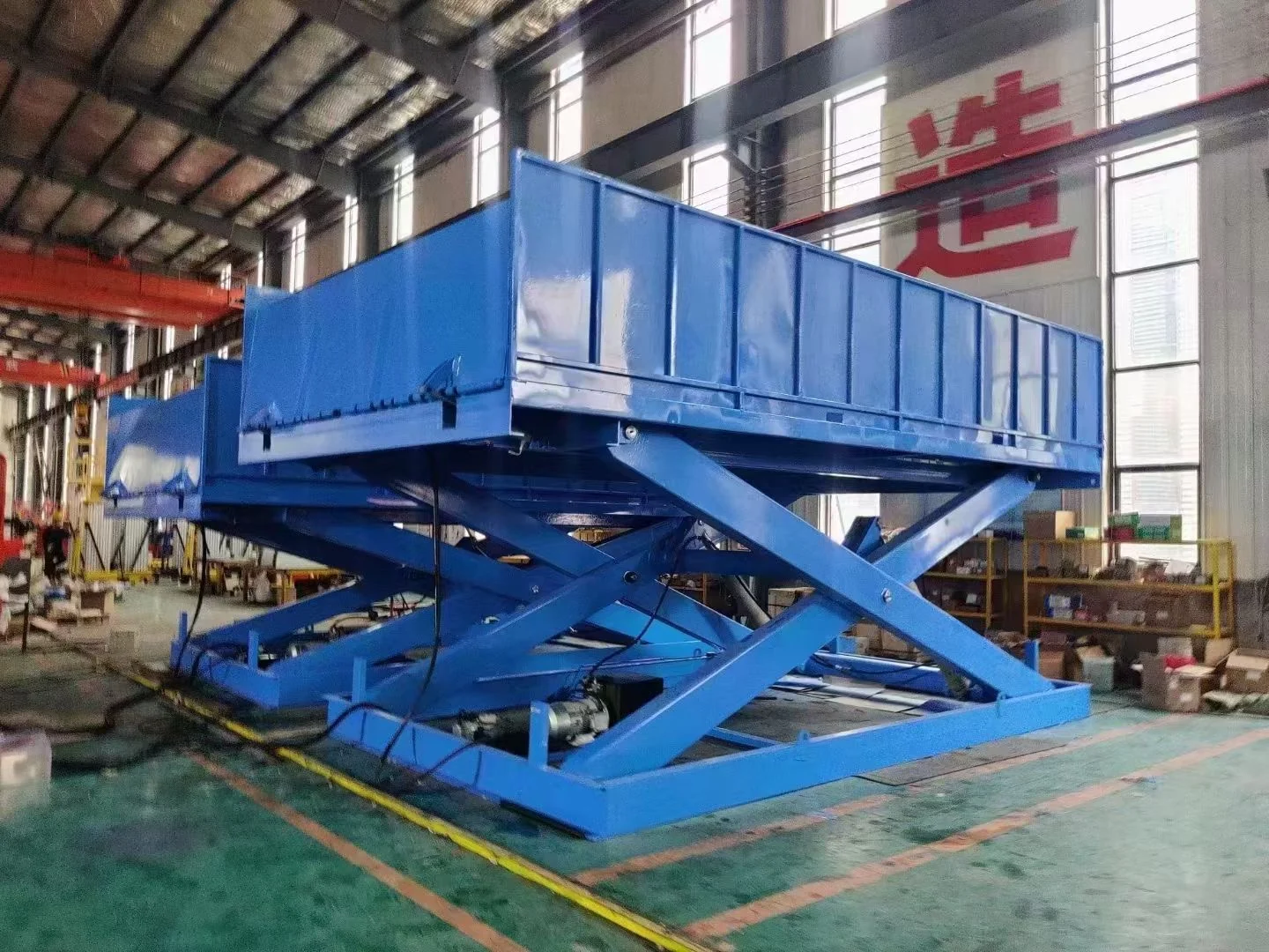 Complete blue fixed scissor lift table with platform and base visible in a workshop