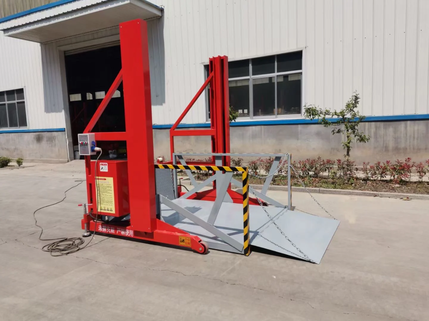 Complete red loading and unloading platform with its bridge plate open outside a building